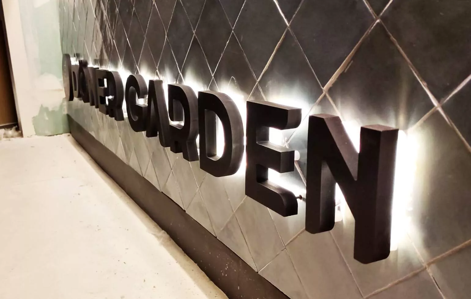Letras corpóreas de acero inoxidable cepillado sobre pared interior en Madrid