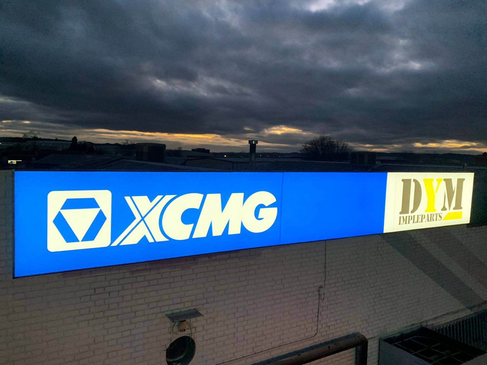 Caja de luz con logotipo iluminado en fachada de comercio
