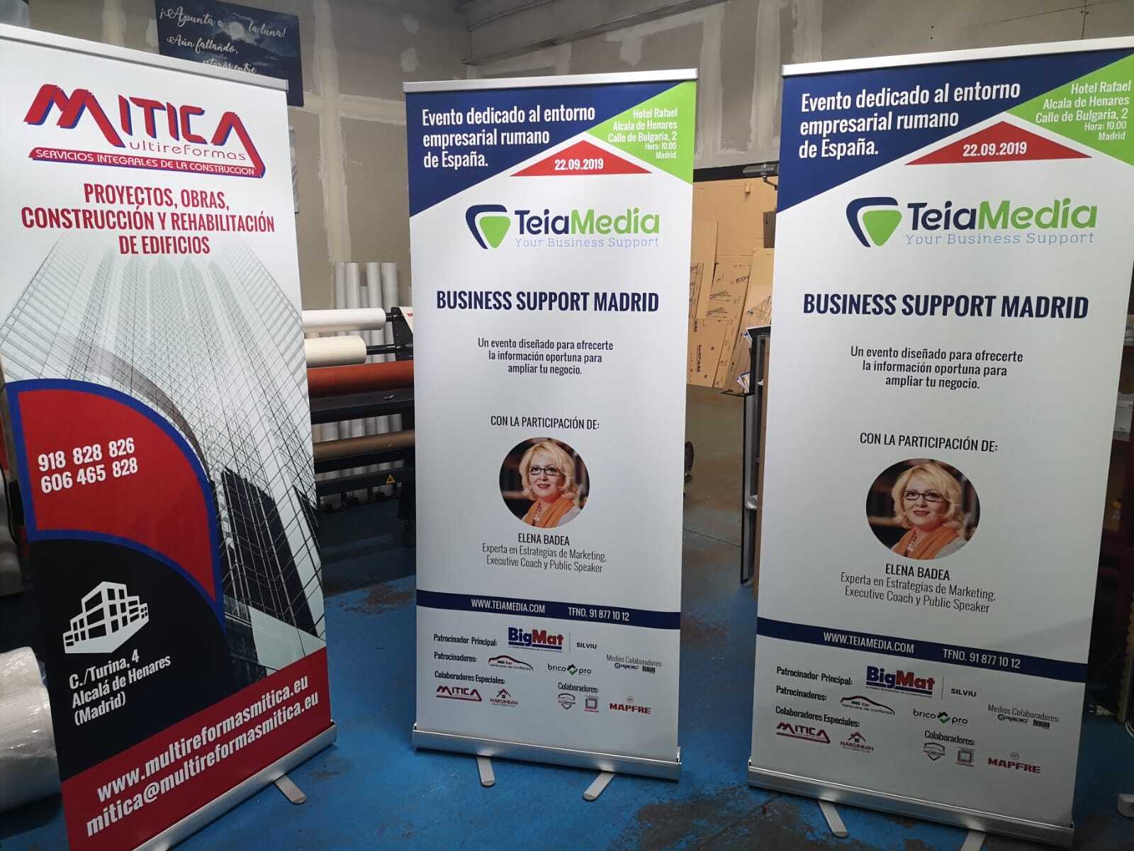 Expositor enrollable con banner corporativo impreso en oficina